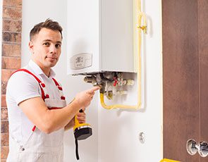 A man in white shirt holding yellow tool near wall.