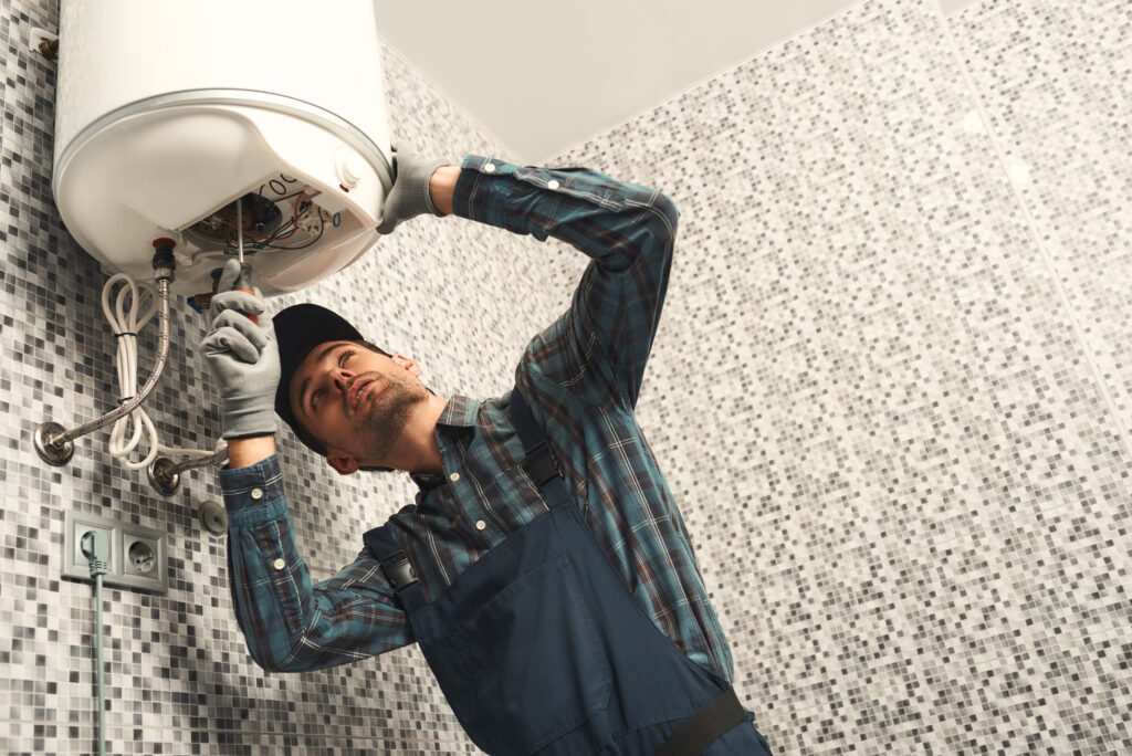 A man in blue shirt holding up a white ceiling fixture.